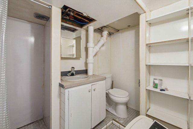 bathroom with vanity, toilet, and tile patterned flooring