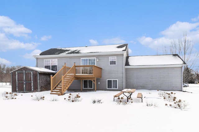 snow covered house featuring a storage unit and a deck