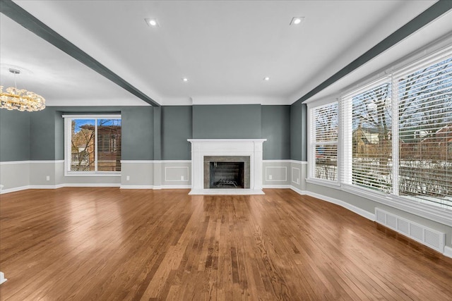 unfurnished living room featuring hardwood / wood-style floors and a notable chandelier