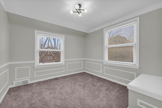 spare room featuring carpet flooring and vaulted ceiling