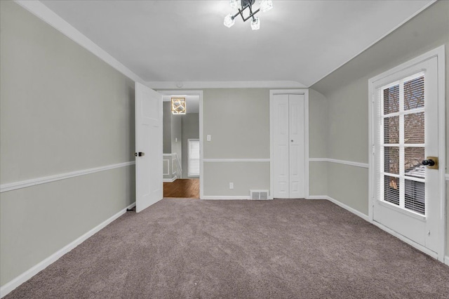 unfurnished bedroom featuring carpet floors, a closet, and vaulted ceiling