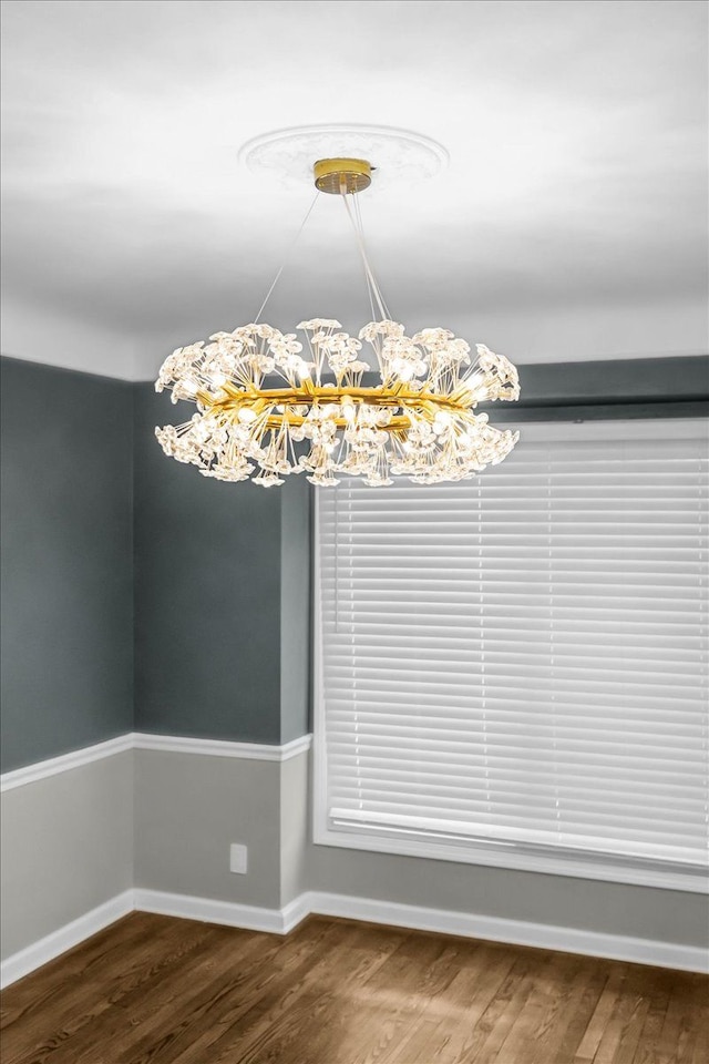 unfurnished dining area featuring hardwood / wood-style floors and a notable chandelier