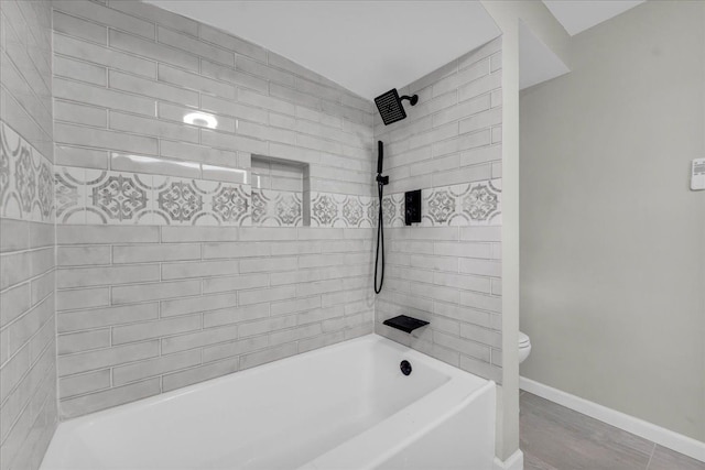 bathroom featuring tiled shower / bath and toilet