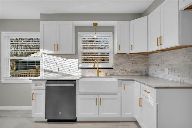 kitchen featuring dishwasher, sink, and white cabinets