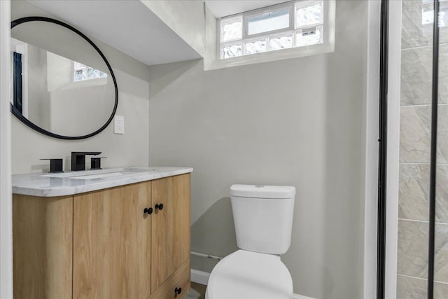 bathroom with plenty of natural light, toilet, and vanity