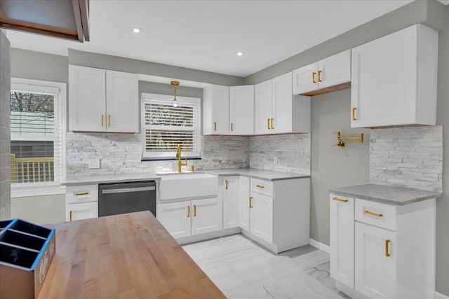 kitchen with dishwashing machine, sink, decorative backsplash, and white cabinets