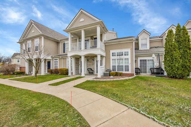 view of front of house with a front lawn and a balcony