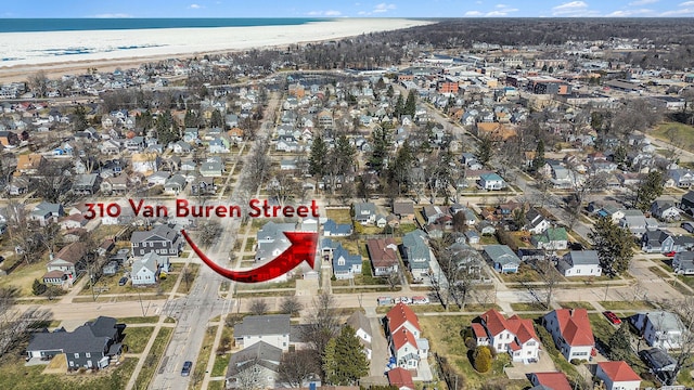 drone / aerial view featuring a residential view, a beach view, and a water view