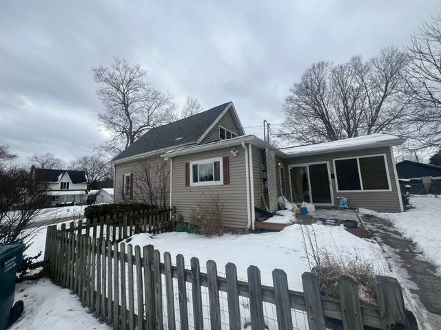 view of snow covered rear of property