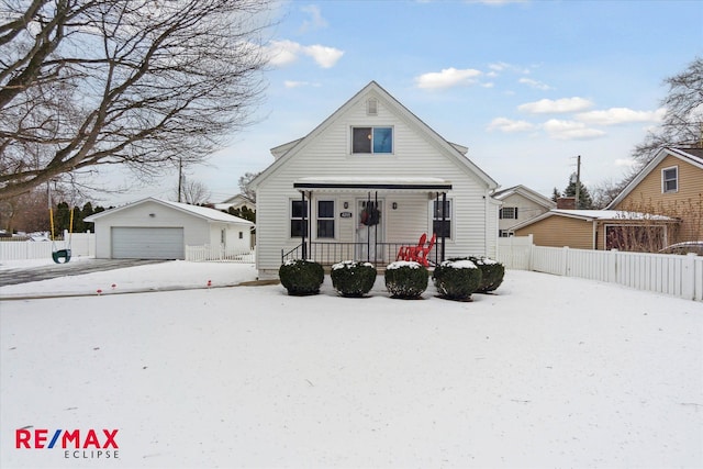 bungalow with a garage, an outdoor structure, and a porch