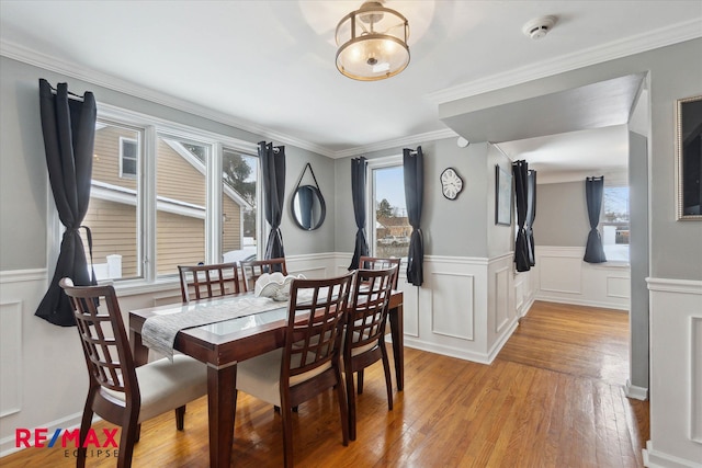 dining area featuring crown molding and light wood-type flooring