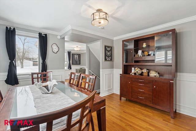 dining room featuring ornamental molding and light wood-type flooring