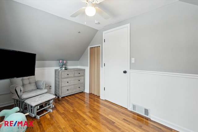 living area with vaulted ceiling, ceiling fan, and light hardwood / wood-style flooring