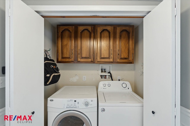 laundry area with independent washer and dryer and cabinets