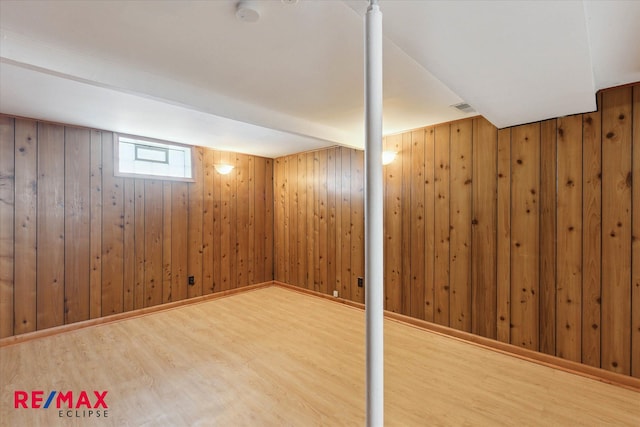 basement with wood-type flooring and wooden walls