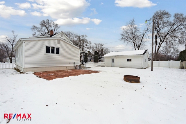 view of snow covered exterior with an outbuilding