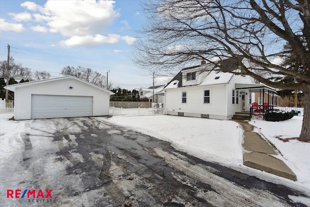 snow covered property with an outbuilding and a garage