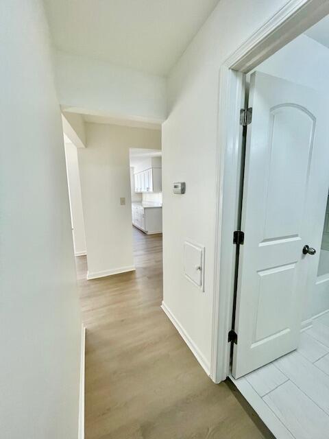 hallway with light hardwood / wood-style floors