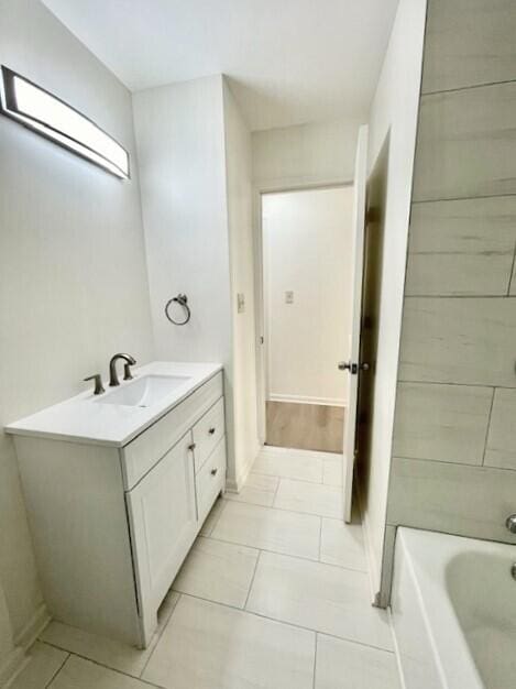 bathroom featuring vanity, tile patterned flooring, and a bathing tub