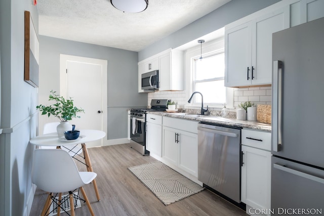 kitchen with stainless steel appliances, sink, and white cabinets