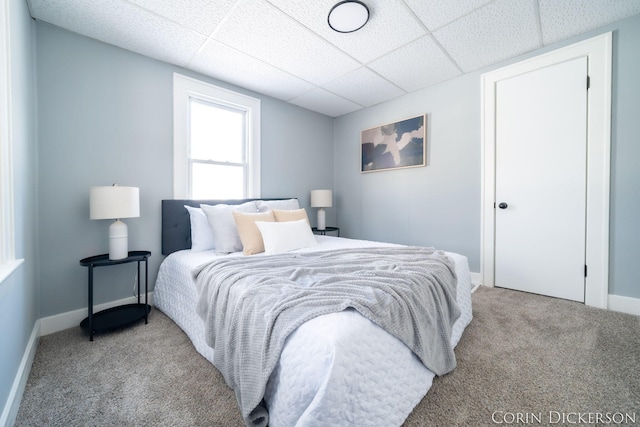 bedroom featuring a paneled ceiling and light colored carpet