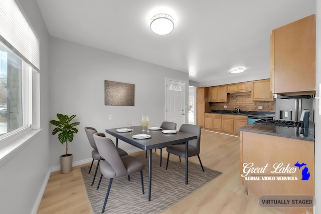 dining room featuring sink, a wealth of natural light, and light wood-type flooring