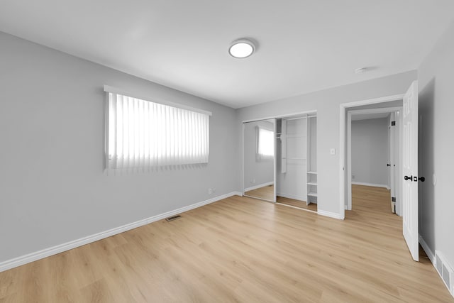 unfurnished bedroom with a closet and light hardwood / wood-style flooring