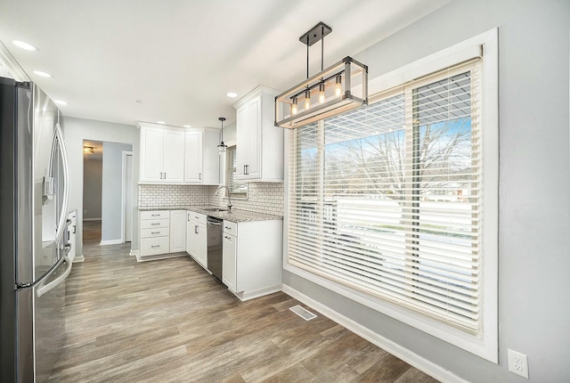 kitchen featuring pendant lighting, sink, white cabinets, and appliances with stainless steel finishes