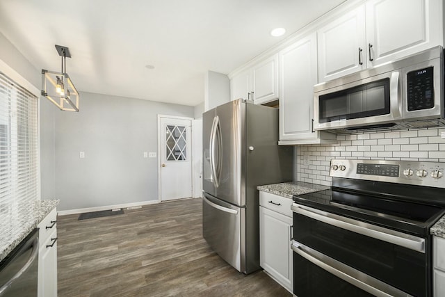 kitchen featuring pendant lighting, tasteful backsplash, white cabinetry, dark hardwood / wood-style flooring, and stainless steel appliances