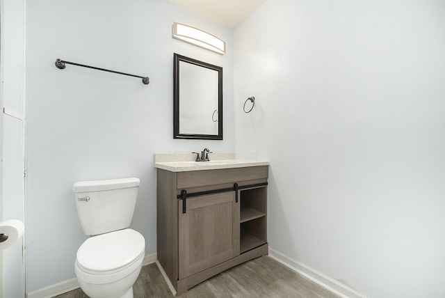 bathroom featuring vanity, toilet, and hardwood / wood-style floors