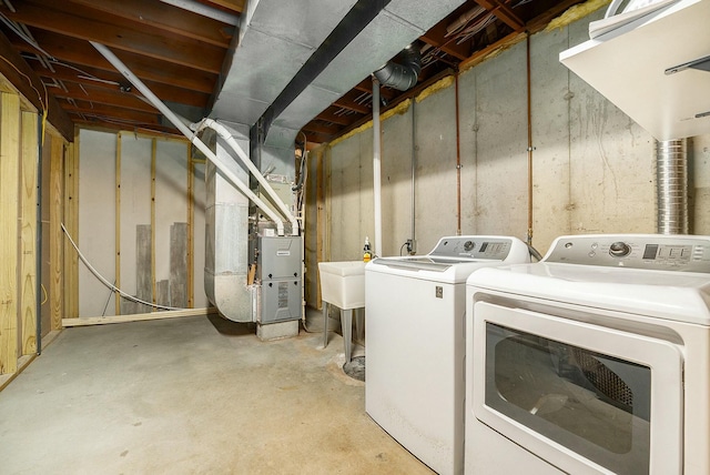 clothes washing area with separate washer and dryer and heating unit