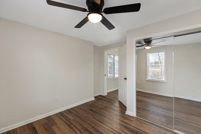 unfurnished bedroom with dark wood-type flooring, ceiling fan, and a closet