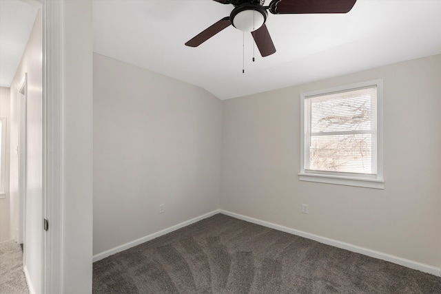 carpeted spare room featuring ceiling fan and vaulted ceiling