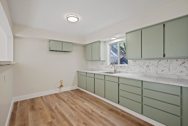 kitchen with green cabinetry, sink, and decorative backsplash