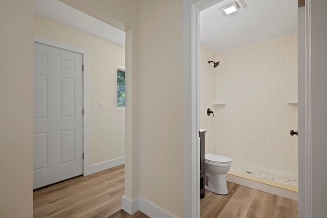 bathroom with wood-type flooring, toilet, and a shower