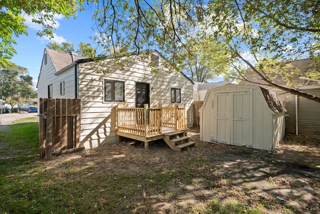 back of house featuring a wooden deck and a storage unit