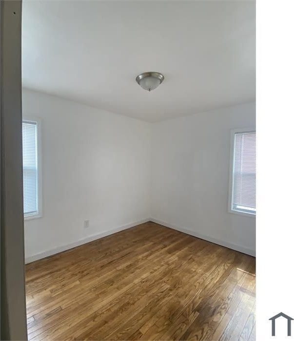 unfurnished room with wood-type flooring