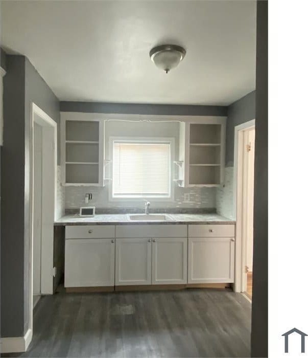 kitchen with dark hardwood / wood-style floors, sink, decorative backsplash, and white cabinets