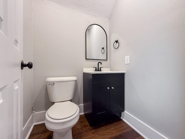 bathroom featuring wood-type flooring, vanity, and toilet