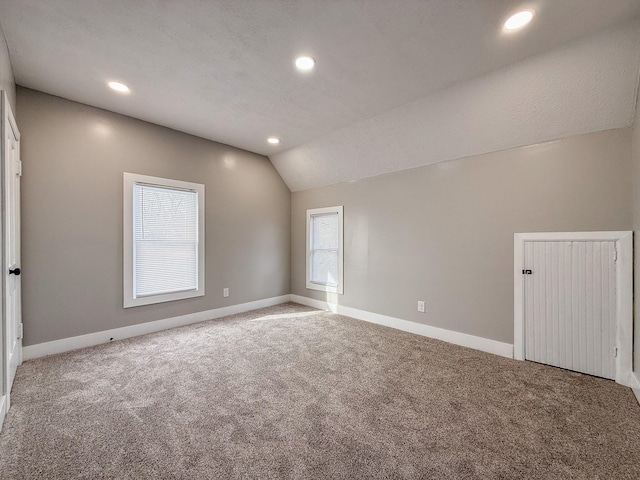 unfurnished room featuring lofted ceiling and carpet