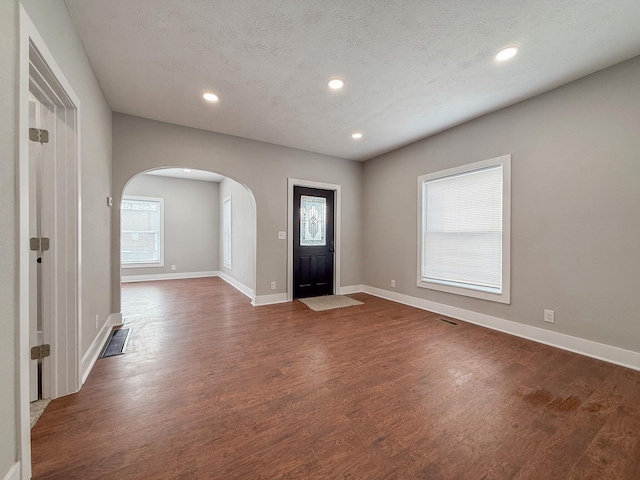 entrance foyer featuring a textured ceiling and dark hardwood / wood-style flooring