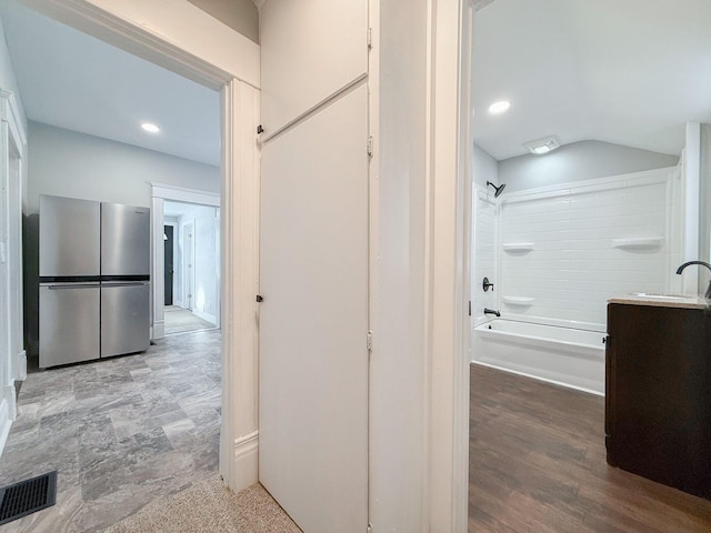 hallway with lofted ceiling and sink