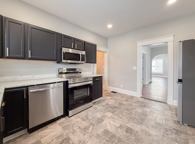 kitchen featuring light stone counters and appliances with stainless steel finishes