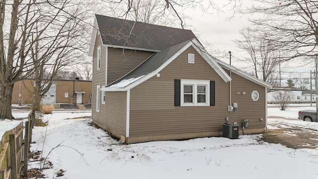 snow covered property featuring central AC unit