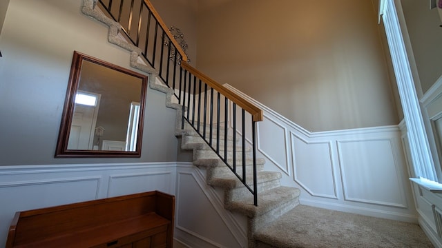 stairway featuring carpet flooring