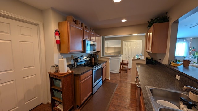 kitchen with dark wood-type flooring, stainless steel appliances, and sink