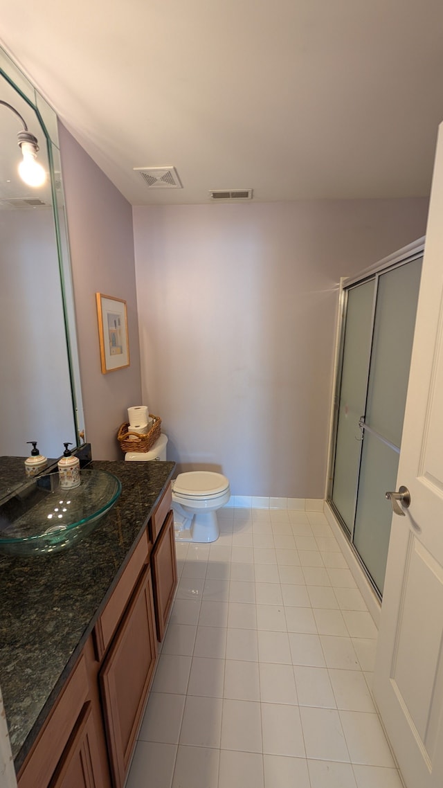 bathroom with vanity, tile patterned floors, toilet, and walk in shower