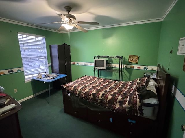 carpeted bedroom with crown molding and ceiling fan