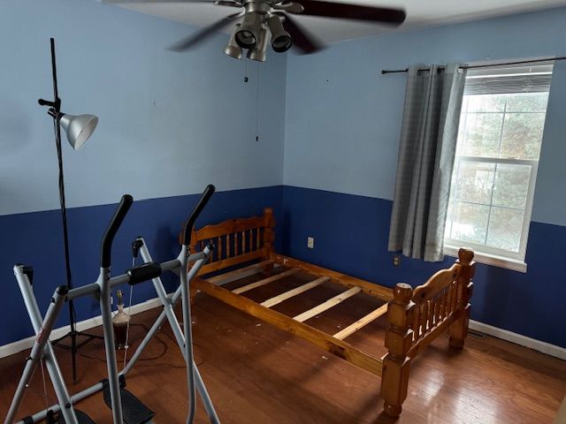 bedroom with multiple windows, hardwood / wood-style floors, and ceiling fan