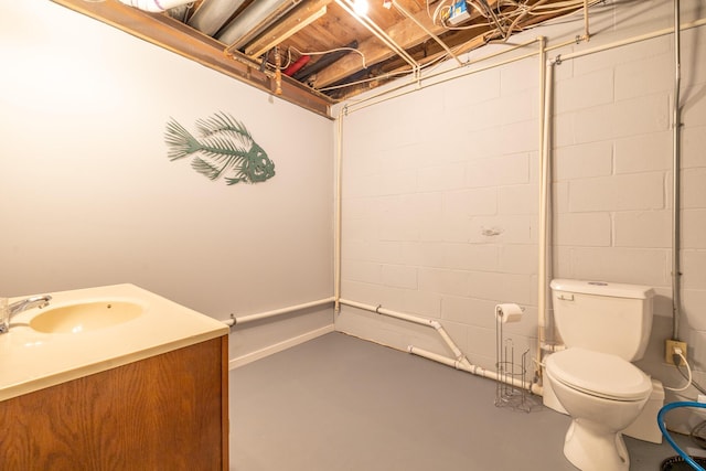 bathroom featuring toilet, vanity, and concrete flooring